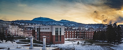 Picture of BHSU Residence Halls with sunset and mountain in the background