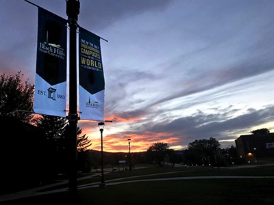 Picture of BHSU sidewalk banners with sunset in the background
