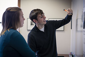 Two BHSU students working together, drawing on a white board