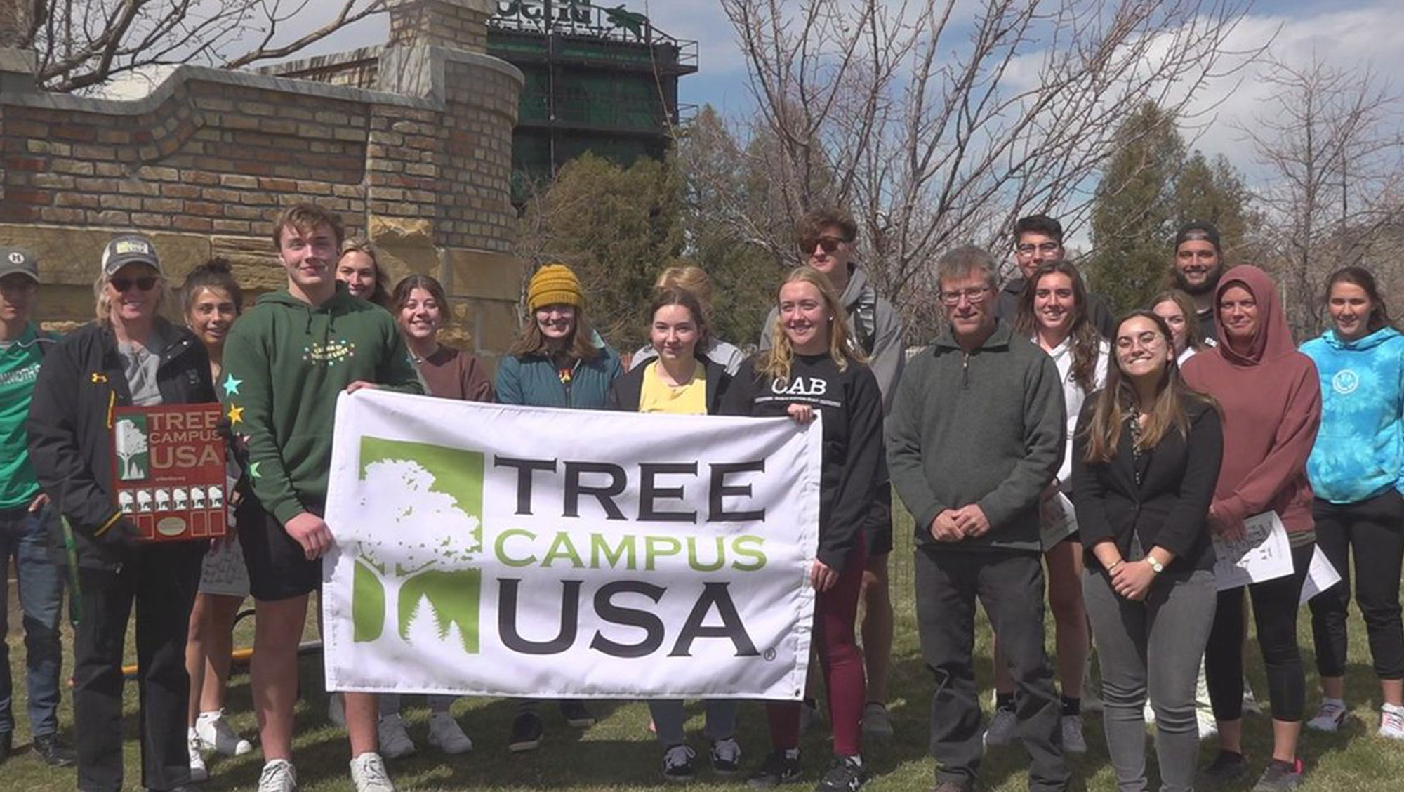Black Hills State University students and staff pose with the Tree Campus USA plaque and banner during their 2022 Arbor Day celebration. 