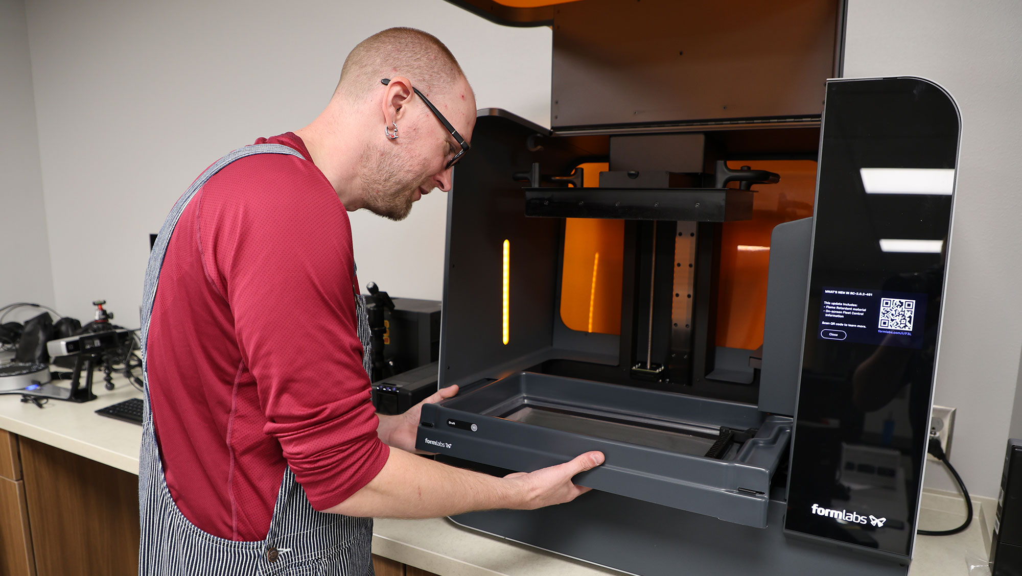 Aaron Bauerly, systems librarian and makerspace coordinator at BHSU, carefully removes the resin tray from the resin 3D printer in the Innovation Lab in the lower level of the E.Y. Berry Library-Learning Center.