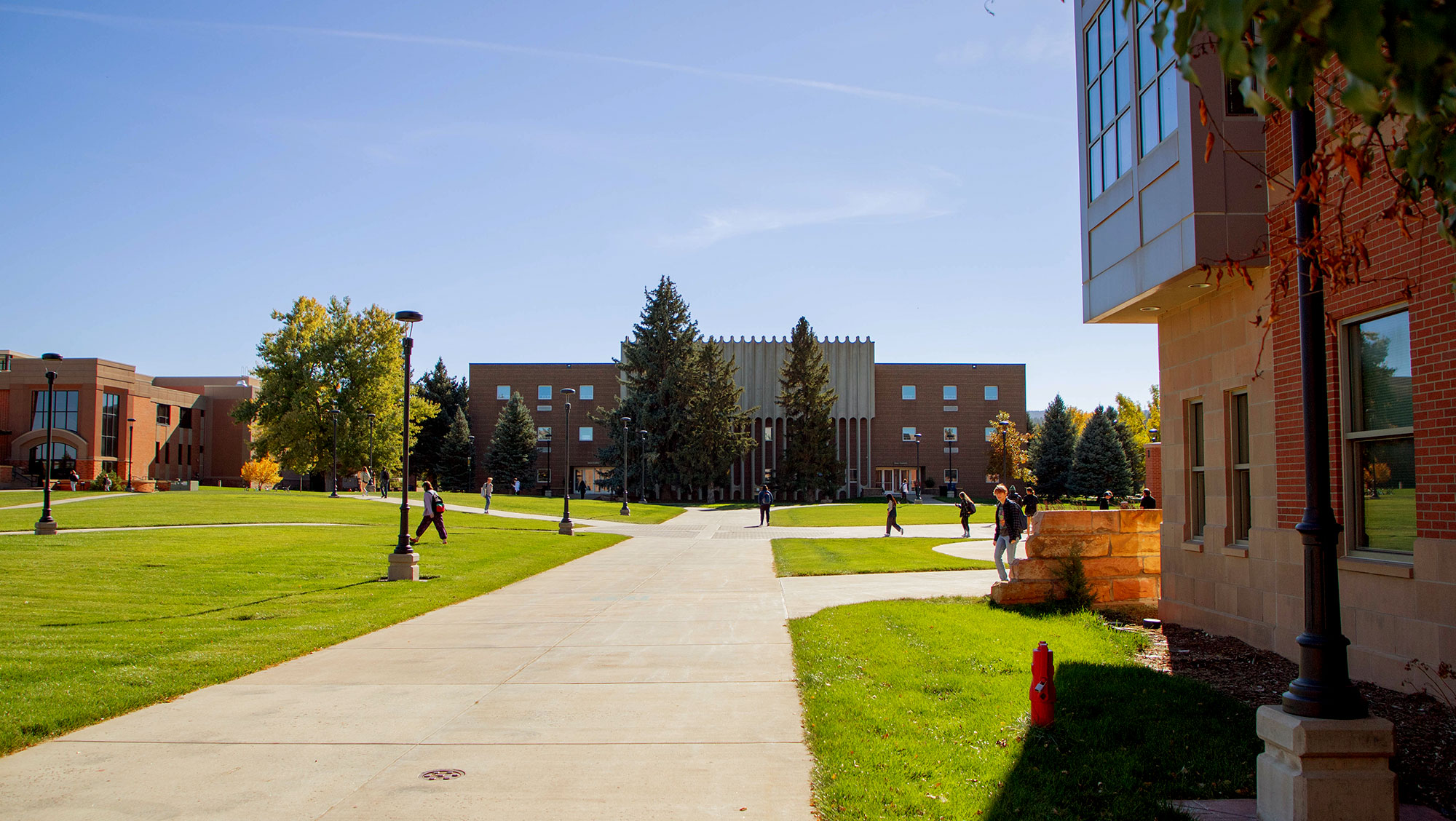Image of Jonas Hall in the late summer. Sunny day. Students are walking across the BHSU campus.