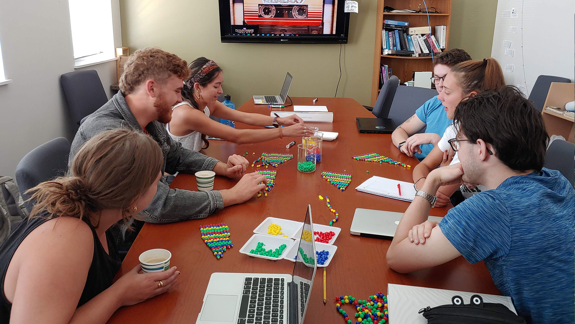 BHSU students sit around a classroom table and arrange colorful popbeads to represent DNA sequencing.