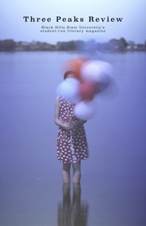 Issue 1 cover: Photo of a girl in a red polka dot dress wading in shallow water, holding red and white balloons – the balloons are intentionally blurred.