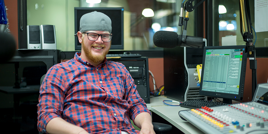 Man poses for photo in The Buzz FM studio.