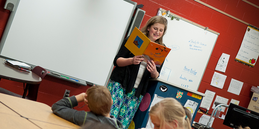 Woman reads to children in a classroom.