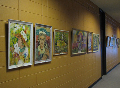 Six of Mar Gretta Cocking's paintings on a yellow wall.