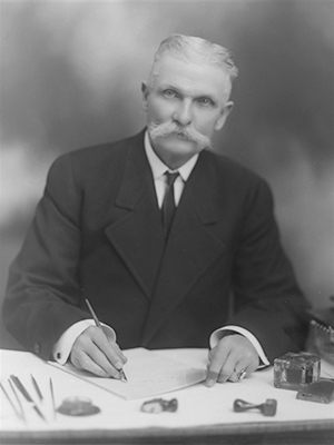 Black and white image of William J. Collins signing a document.