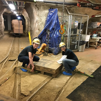 Two REU students working underground in a tunnel.