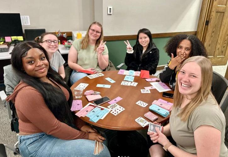 Five international students and Kaitlin Palmer, Director of International Relations, pose for a photo.