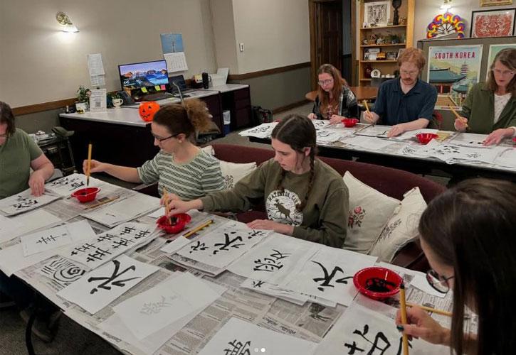 Students work on Japanese calligraphy.