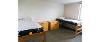 Interior of a Thomas Hall room with a bed on each wall, and a desk next to each bed. 