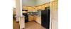 Kitchen of a Yellowjacket Apartment, showing the stove, cabinet space, and the refrigerator. 