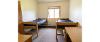 Double bedroom of a Yellowjacket Apartment, showing a bed along each side of the wall. 