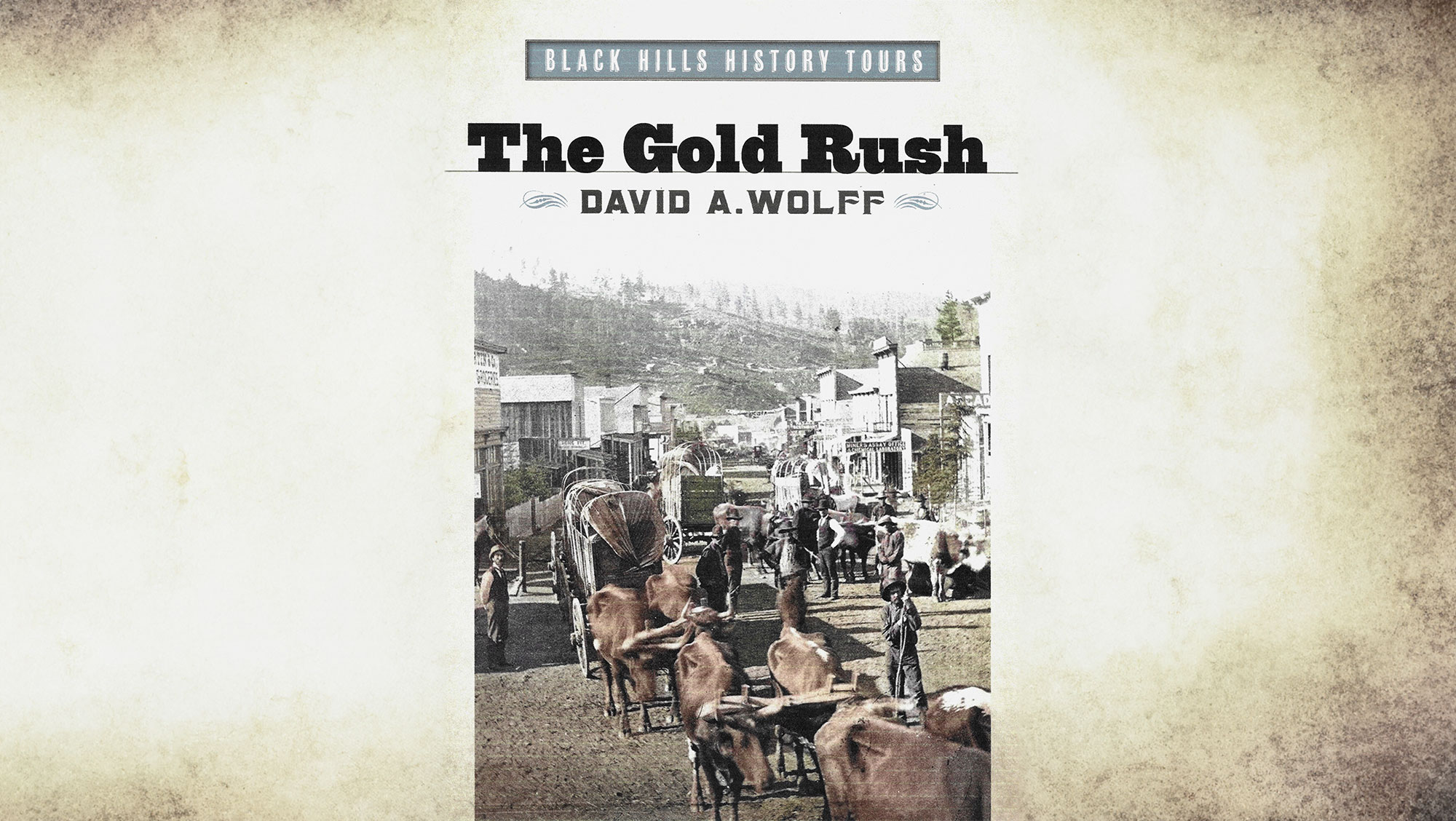 Book cover for Black Hills History Tours Series titled "The Gold Rush" by David A. Wolff, featuring a historical black and white photograph of a bustling historic Deadwood with settlers and horses.