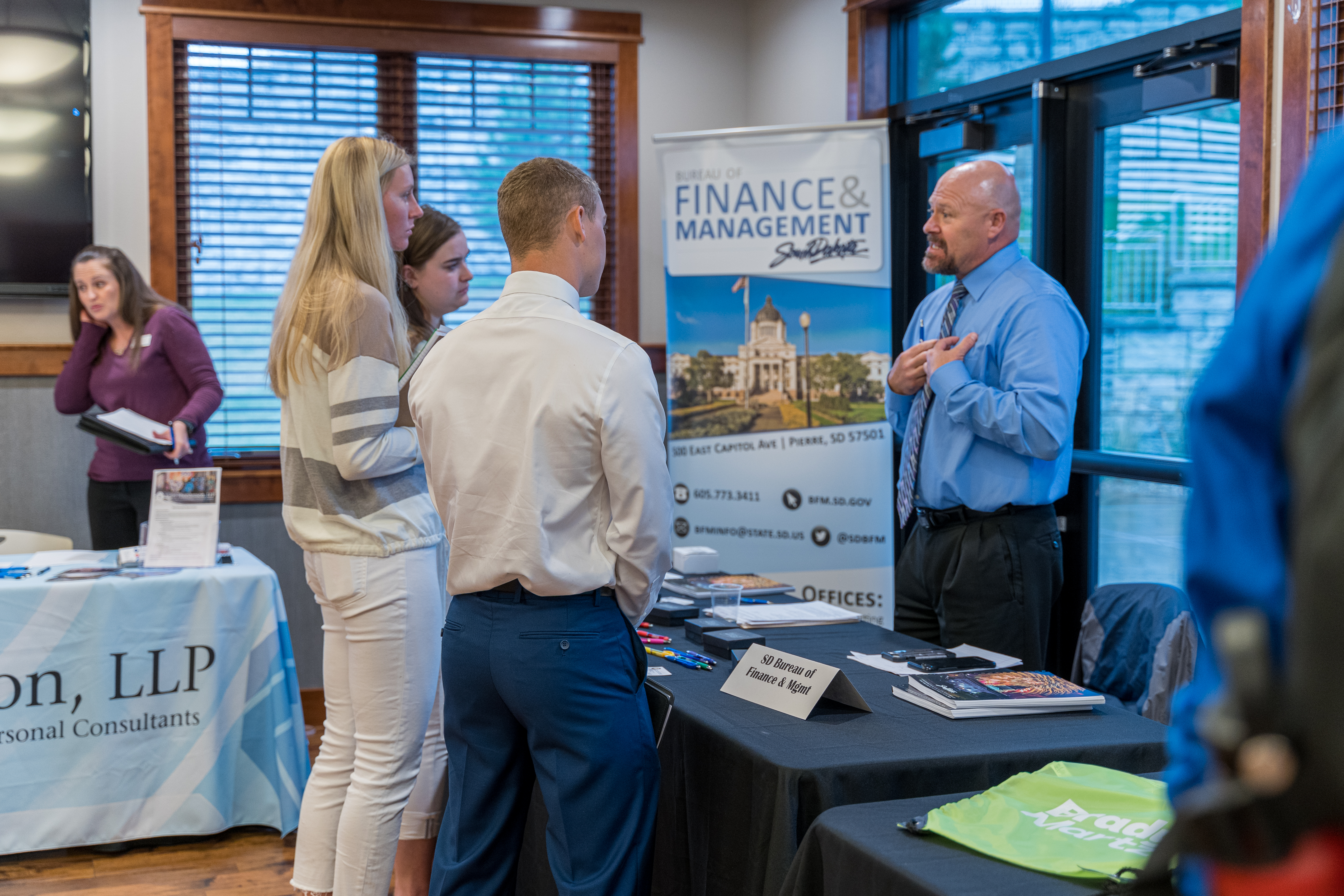 Three BHSU Accounting students asking questions at a booth at a BHSU Accounting Fair.