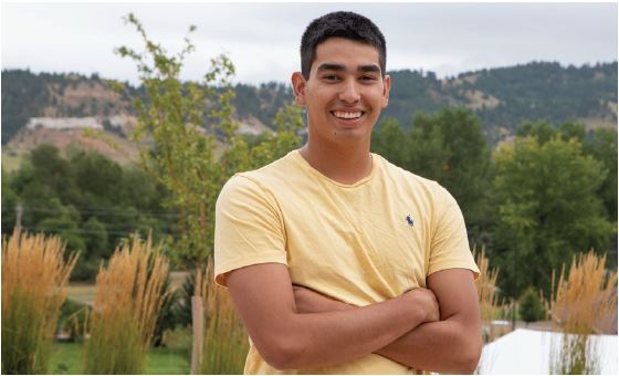 2022 American Indian Studies Degree Graduate, Jacey Garcia with the Black Hills in the background.