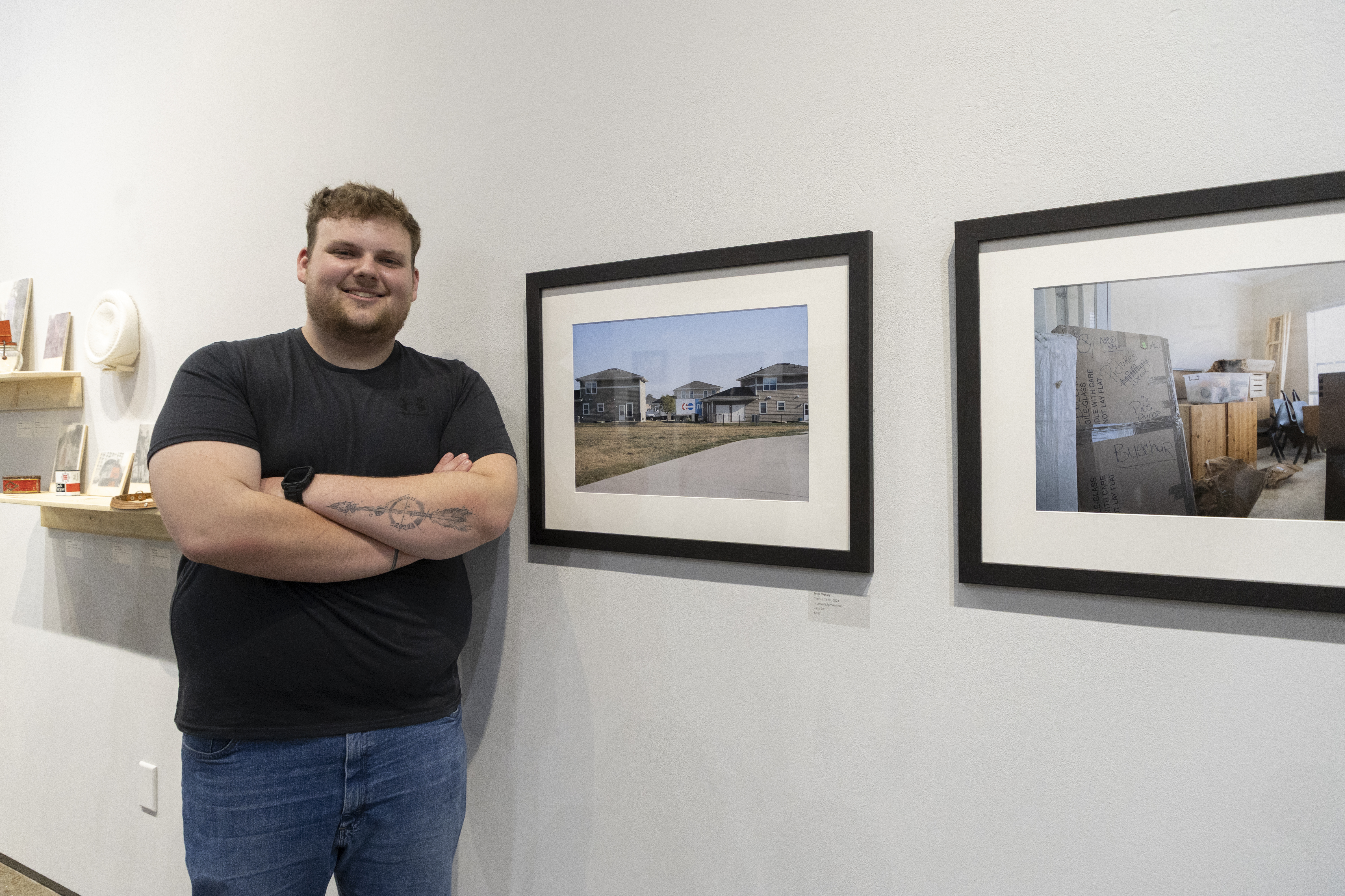 A photography senior shows off his work at the Senior Art Show.