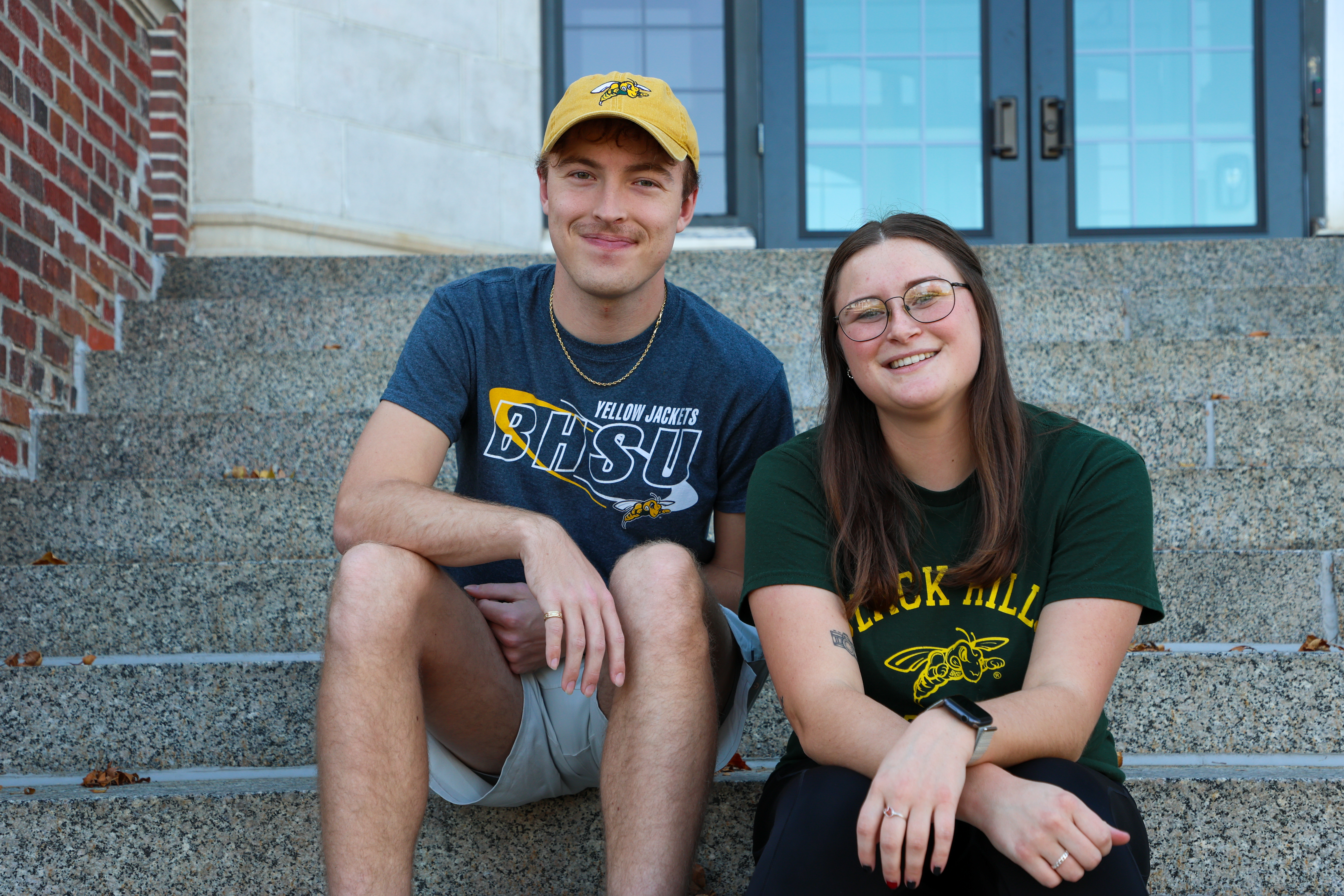 Two BHSU students sitting on the stairs of Woodburn Hall.