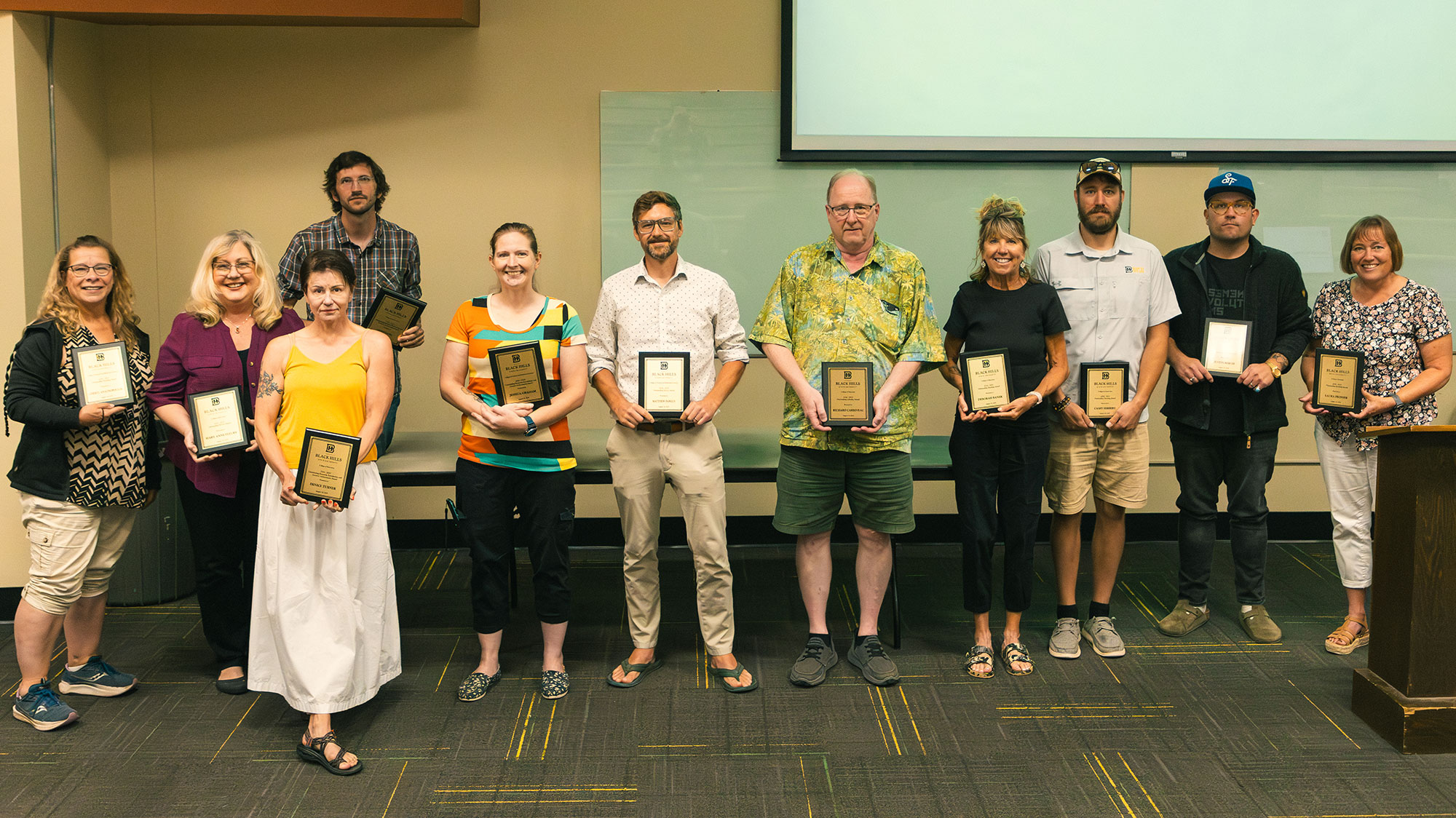 2024-2025 faculty award winners standing with their plaques.