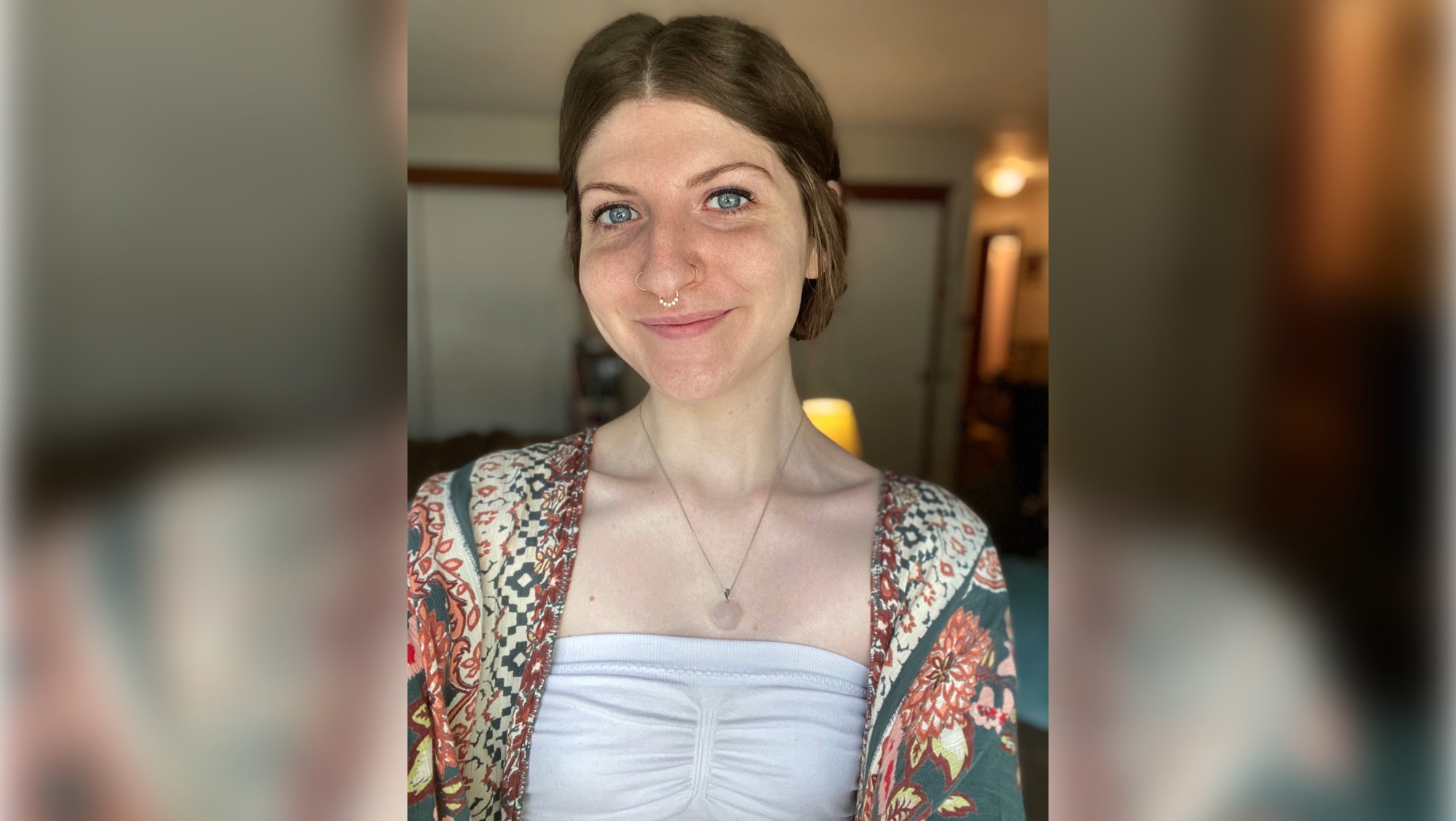 Photo shows a freckled woman with brown hair and blue eyes. 