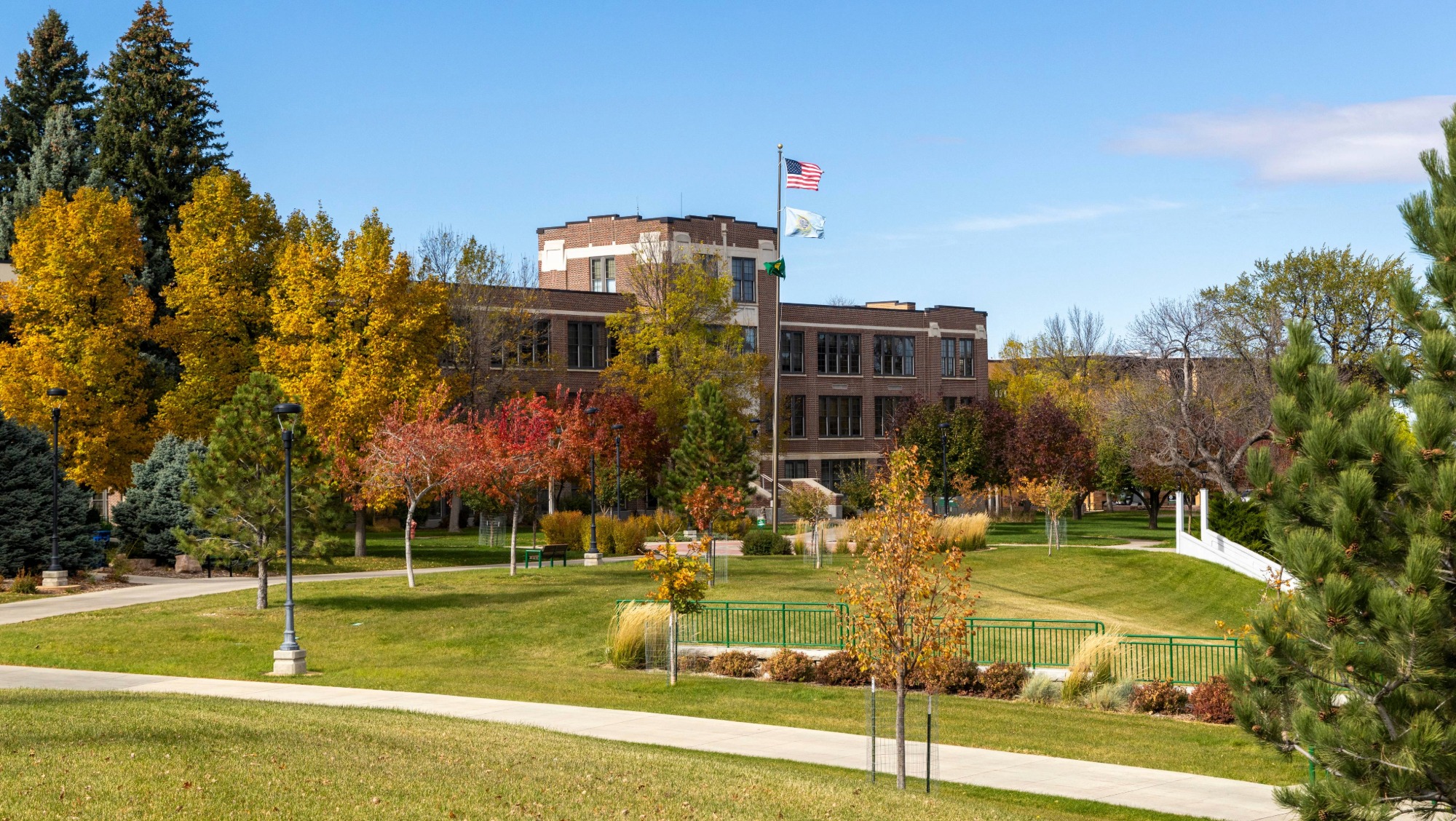 A fall day on the BHSU campus, showing a building with flags in front of it