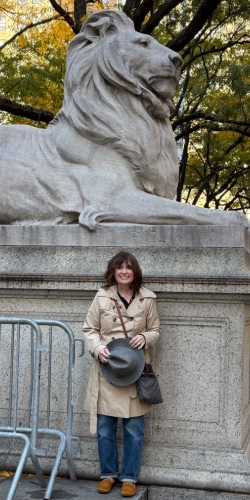 Courtney Huse Wika stands in front of a lion statue