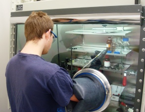 A student using the nitrogen filled glovebox for sample preparation and processing.