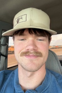 A graduate smiles at the camera